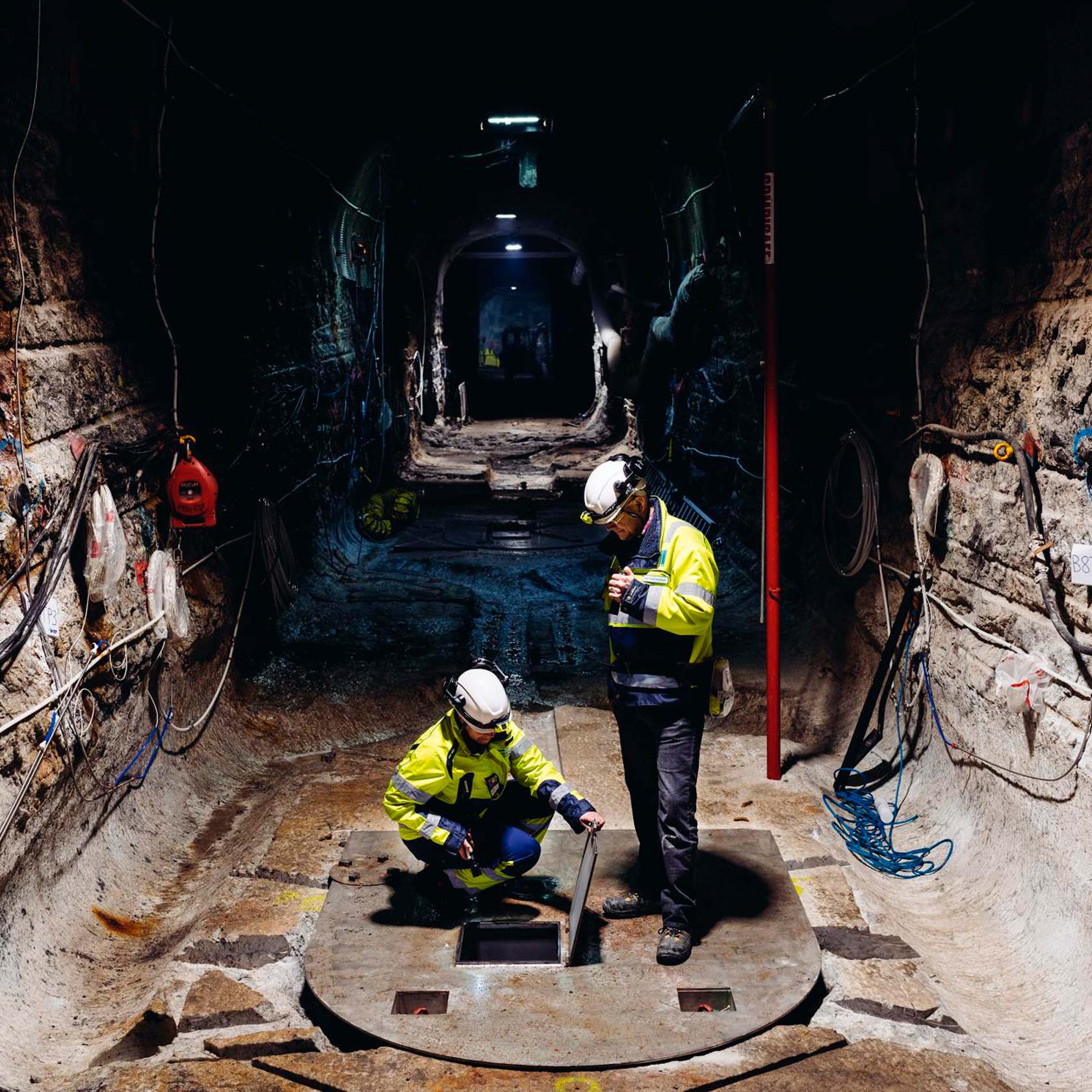 Två medarbetare i en tunnel i anläggningen för slutförvar av använt kärnbränsle. Foto: Posiva