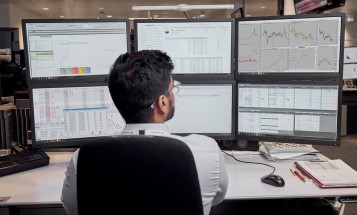 En anställd på Vattenfalls trading-avdelning vid sitt skrivbord med flera skärmar