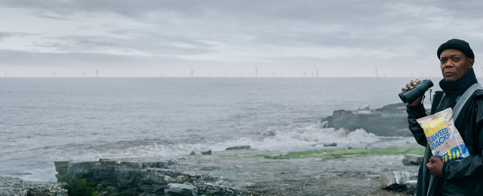 Samuel L. Jackson by a coastline with a wind farm visible in the distance.