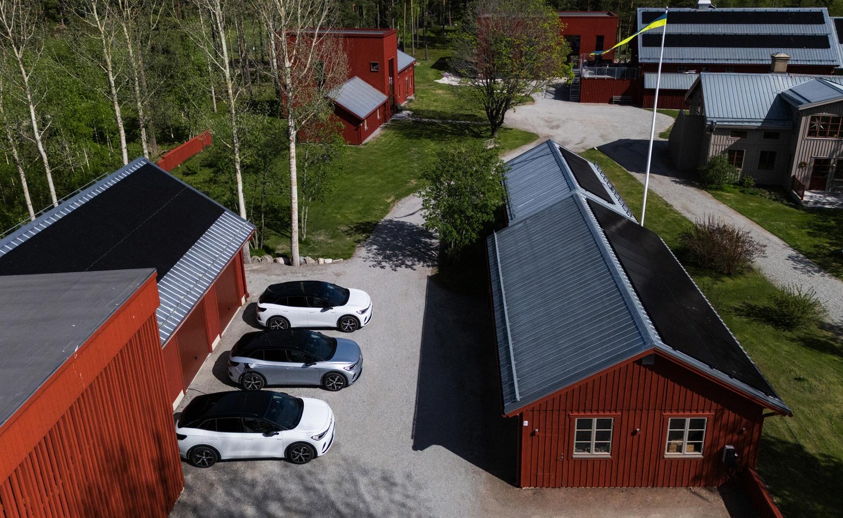 Electric cars parked between red wooden houses in the Stenberg housing association.