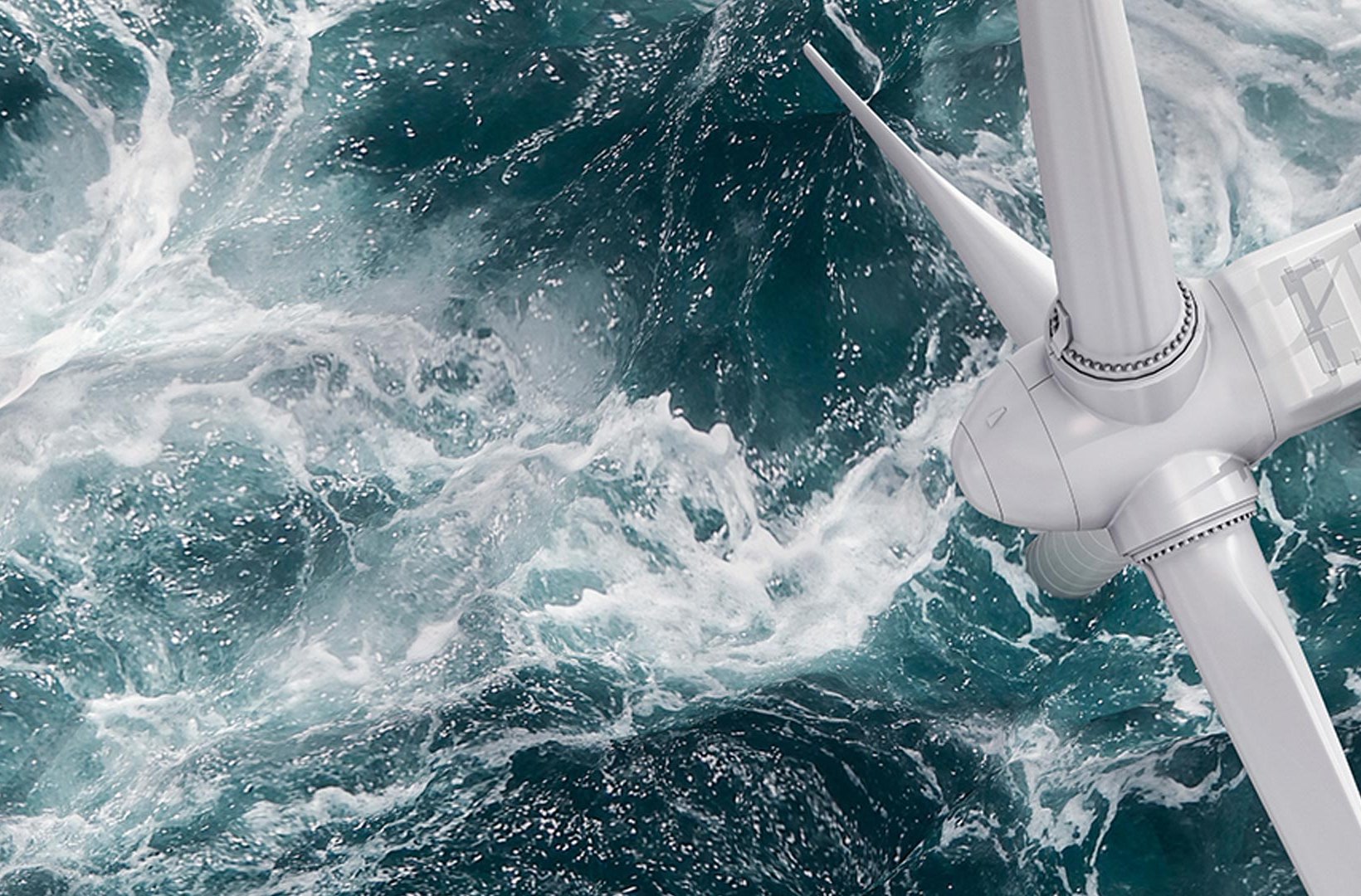 Close-up of a wind turbine above churning sea water.