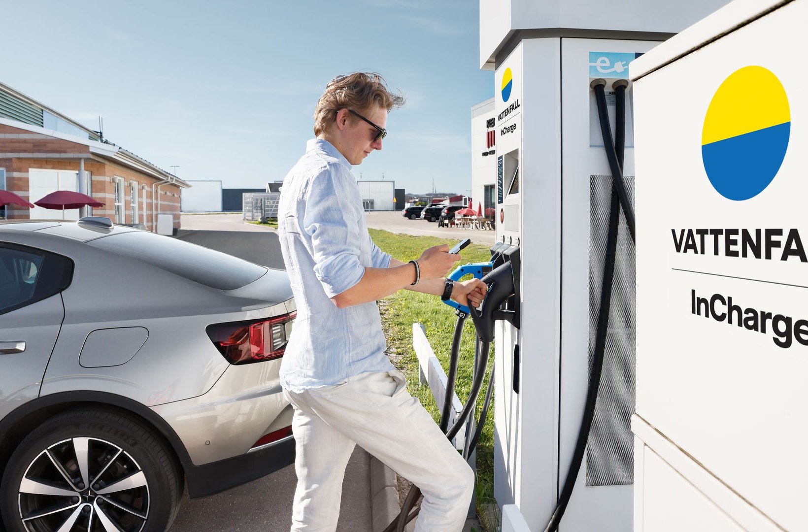 Man charging an electric vehicle at a public e-mobility station Man charging an electric vehicle at a public e-mobility station