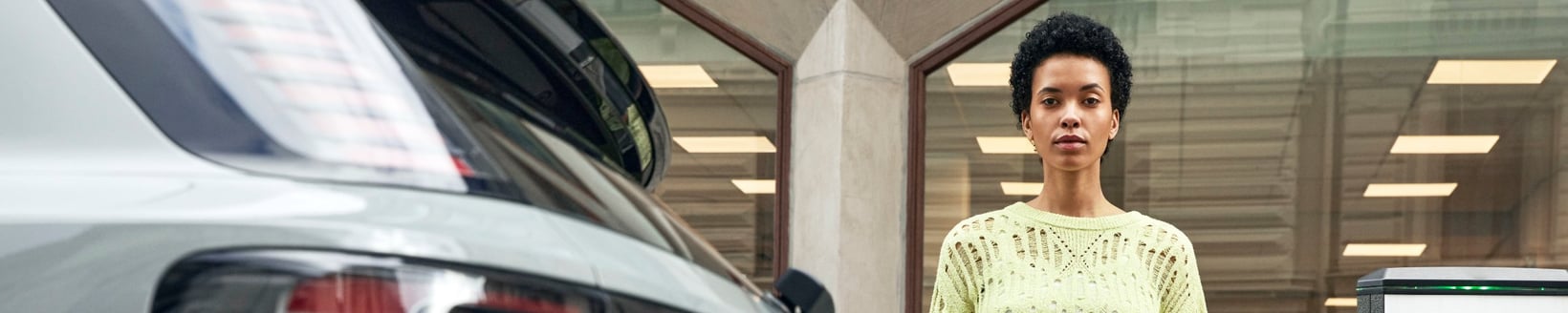 Woman standing next to an electric car