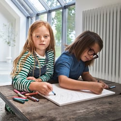 Two children drawing at a table