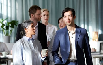 A group of people walking through an open-plan office