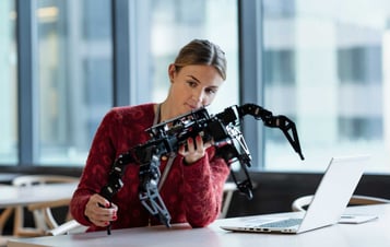 Technician looks at a robot