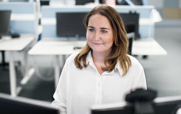 A woman at her desk in an office. A woman at her desk in an office.