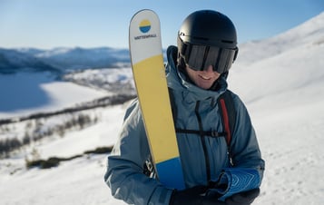 A skier holding skis made with material from rotor blades