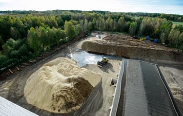Biomass facility with large piles of biomass and a wheel loader. Biomass facility with large piles of biomass and a wheel loader.