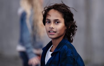 Boy with black hair looking into camera