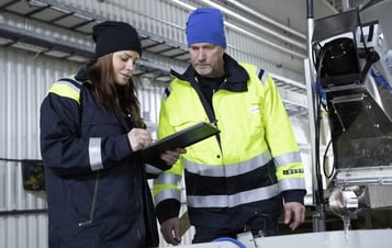 A female and a male employee checking a clipboard