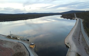 The reservoir at Harsprånget hydro power plant, bordered by forest, with a road running along the shoreline.