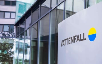 A sign with Vattenfall's logo in front of a glass-fronted building.
