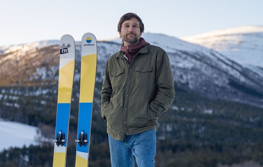 Endre Hals, founder of Evi Ski, standing next to a pair of skis made with parts from a wind turbine