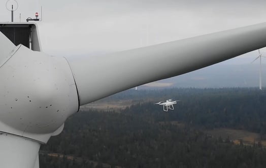 Drone inspecting wind turbine
