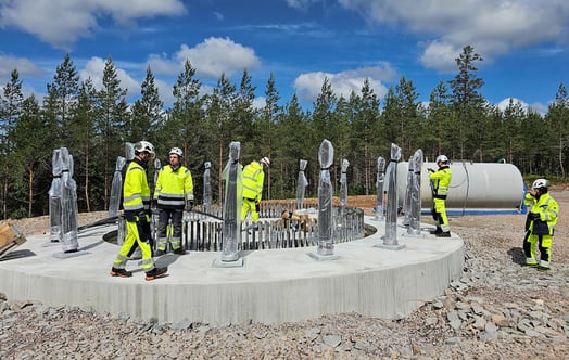 Workers in safety gear on a circular concrete wind turbine foundation. Workers in safety gear on a circular concrete wind turbine foundation.