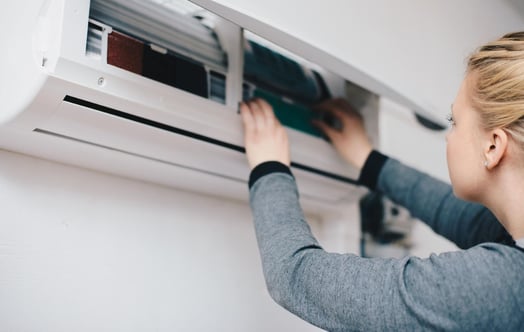 Woman adjusting a heat pump.