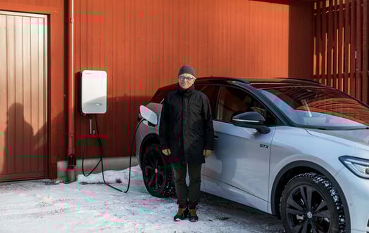 A man is standing in front of a car in a winter landscape.
