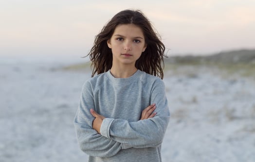 A girl on a beach looking into the camera