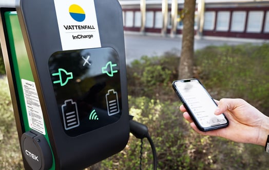 A person using a mobile phone at a charging point for electric vehicles