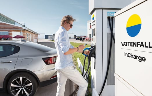 Man charging an electric vehicle at a public e-mobility station
