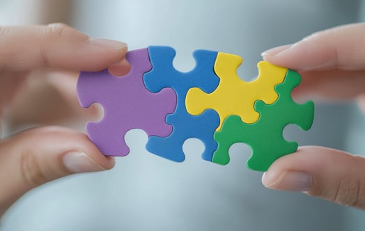 Hands holding pieces of a jigsaw puzzle