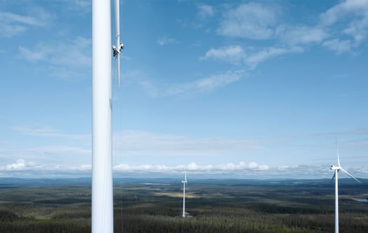 Two maintenance workers on a turbine rotor blade in an onshore wind farm.