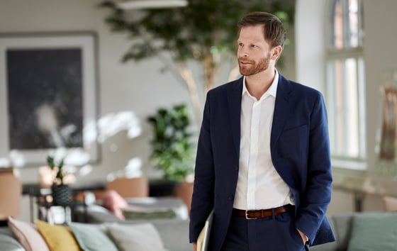 Man in a blue suit standing in a lounge area