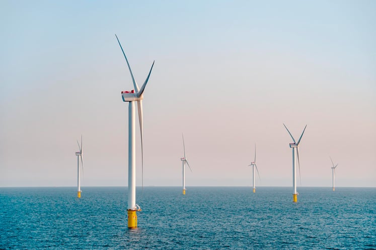 Offshore wind turbines under a clear sky.