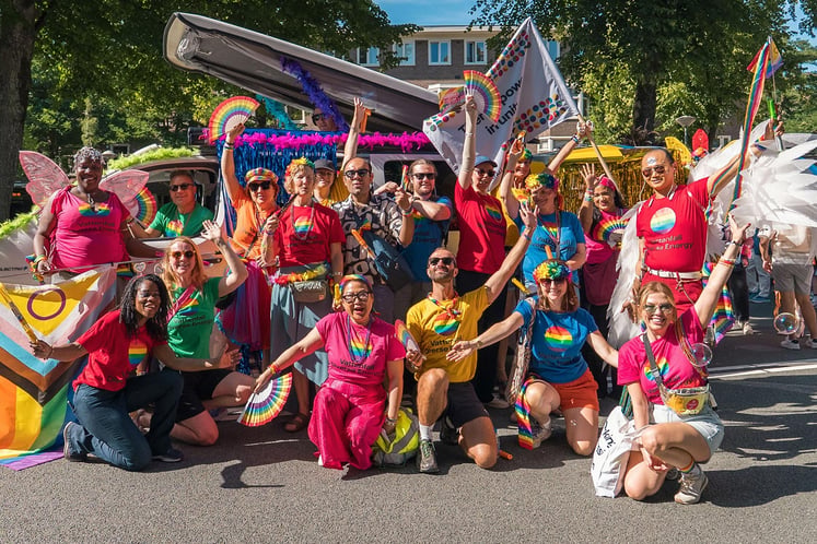 A group of Pride participants in colourful outfits.