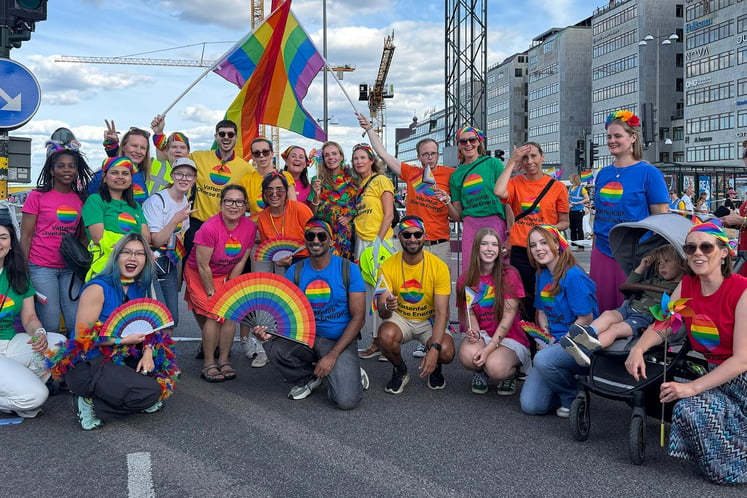 Vattenfall employees posing with rainbow flags on a street in Stockholm.