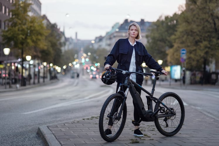 A young woman with her bike on a street in central Stockholm