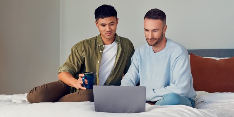 Two men sitting on a bed