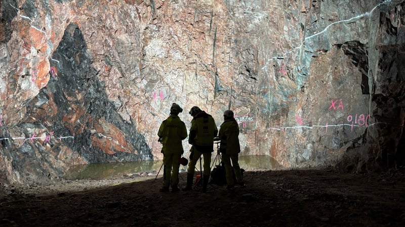 three people standing in a cave