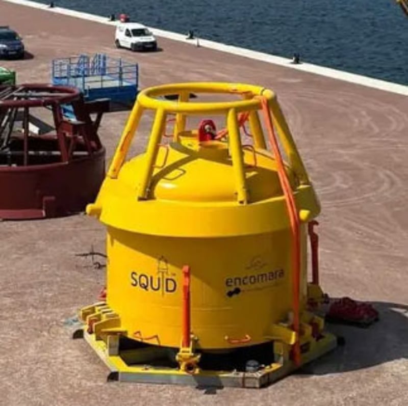 Yellow offshore buoy on a harbor quay next to the sea.