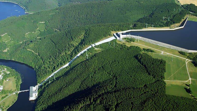 Aerial view of the Hohenwarte II pumped storage power plant and reservoir surrounded by dense forest.
