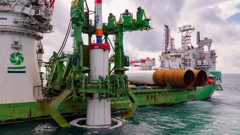 Vessel installing wind turbine foundations at sea.
