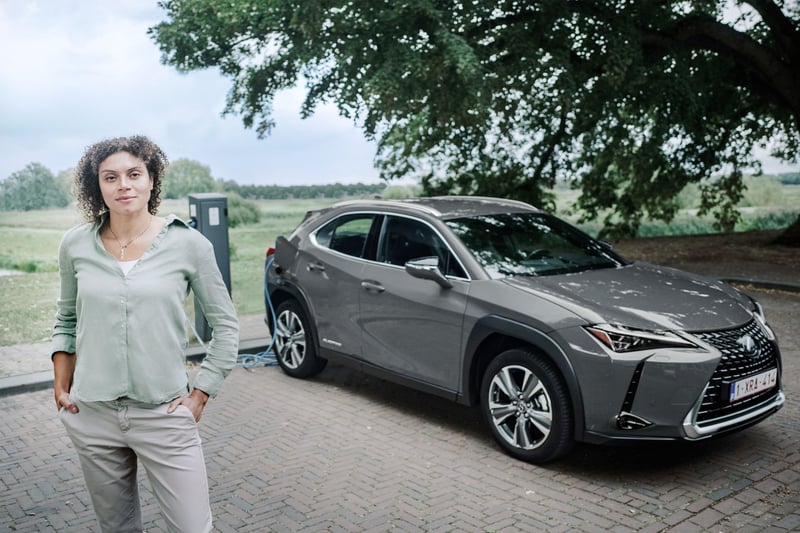 A woman standing next to an electric car