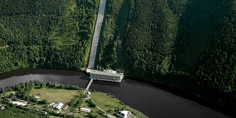 Hydropower plant with dam and surrounding forest seen from above. Photo: Rainer Weisflog.