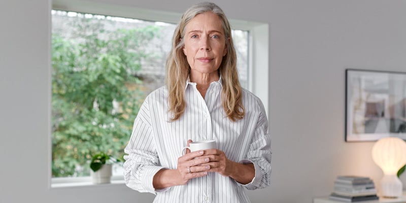 Woman holding a cup looking into the camera