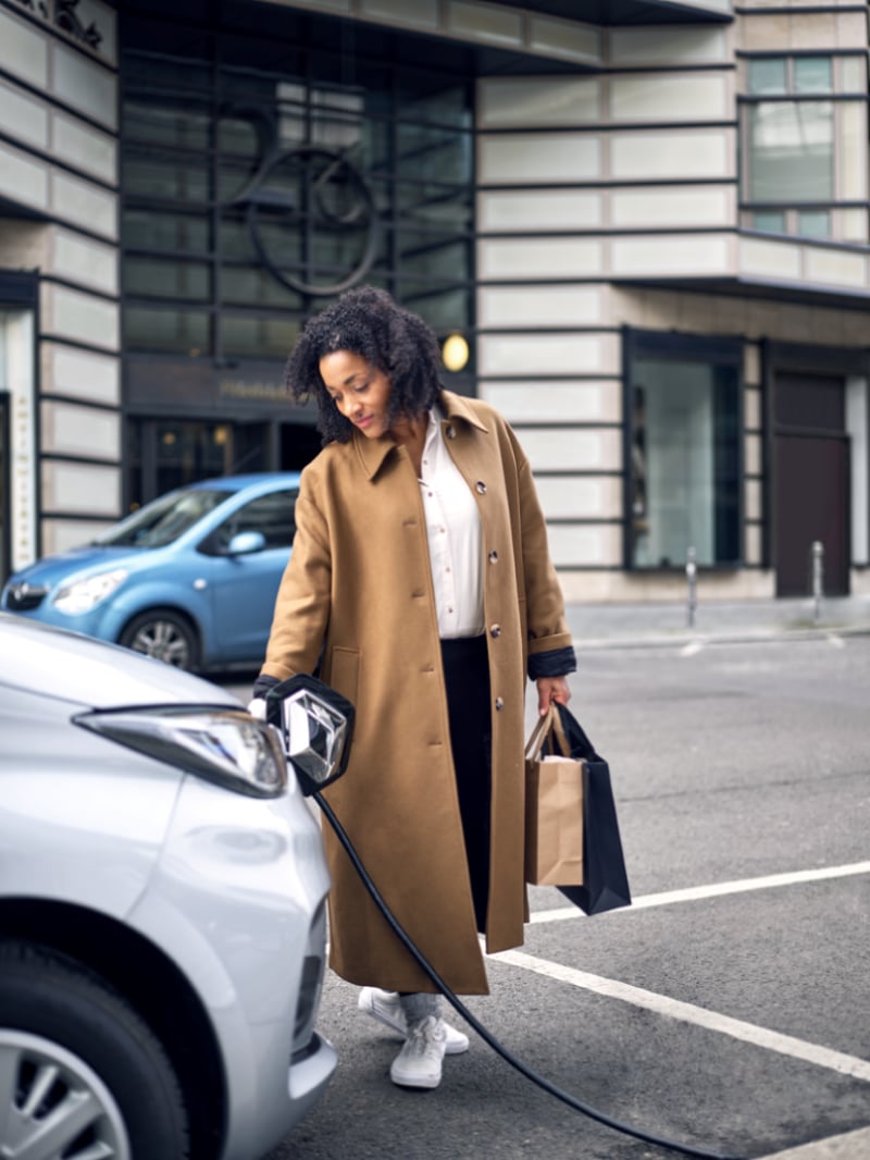 Woman charging an electric vehicle