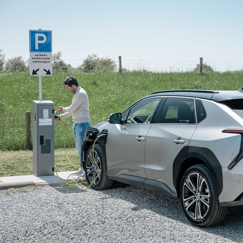 Man charges electric vehicle at charging station.