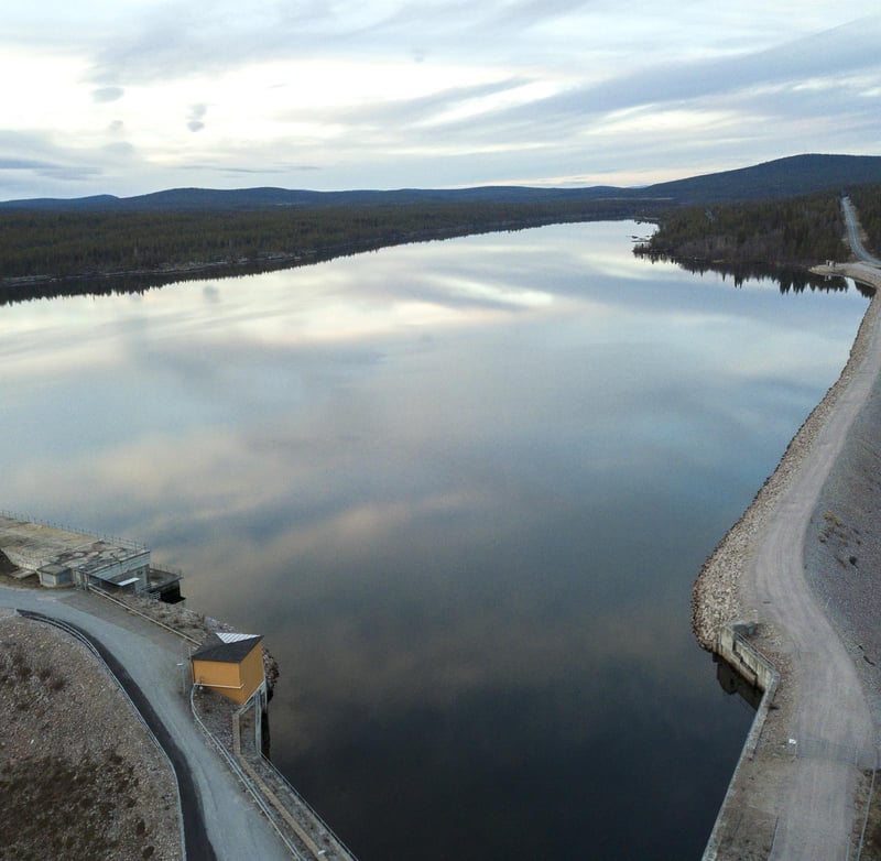 The reservoir at Harsprånget hydro power plant, bordered by forest, with a road running along the shoreline.