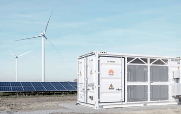 Batteriespeichereinheit neben Solarmodulen und Windkraftanlagen. Batteriespeichereinheit neben Solarmodulen und Windkraftanlagen.