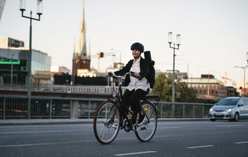 Frau mit Schutzhelm auf einem Fahrrad fahrend