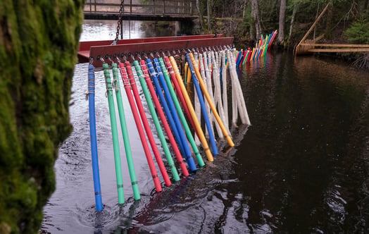 Bunte Kunststoffstäbe, in einer Reihe aufgehängt. Foto: Johan Gunséu.