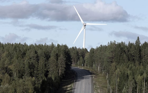 Eine Windkraftanlage ragt über einer Waldstraße in Nordschweden empor. Eine Windkraftanlage ragt über einer Waldstraße in Nordschweden empor.