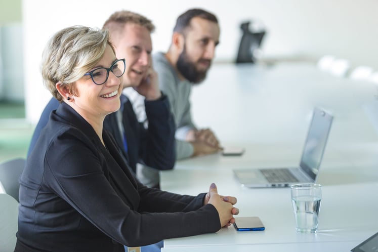 Eine Frau und zwei Männer sitzen am Tisch