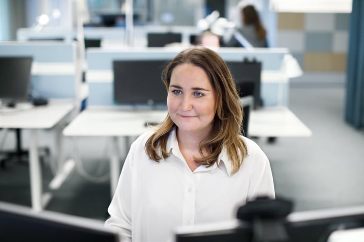 Eine Frau an ihrem Schreibtisch in einem Büro. Eine Frau an ihrem Schreibtisch in einem Büro.