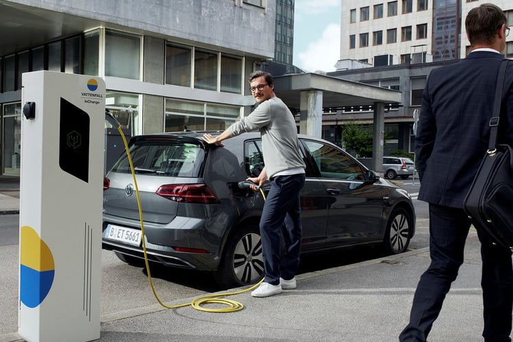 Mann lädt Elektroauto